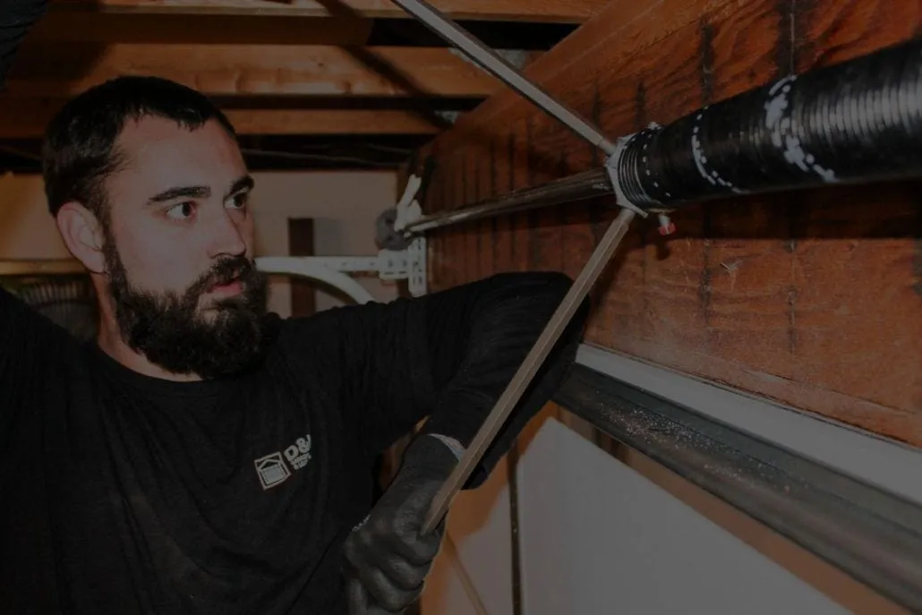 Technician repairing garage door spring